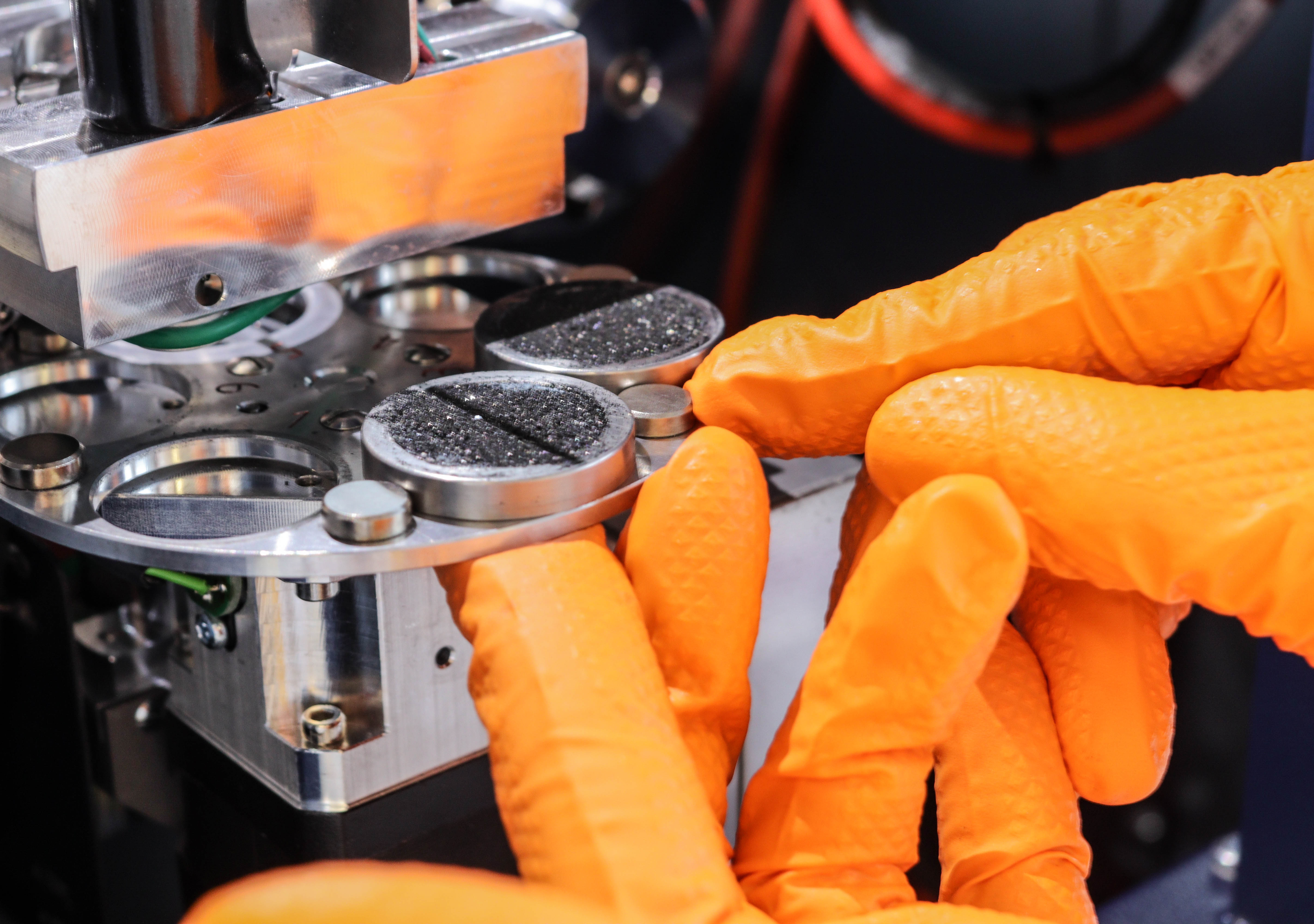 CloseUp-Orange-Gloves-Using-Analytical-Instrument